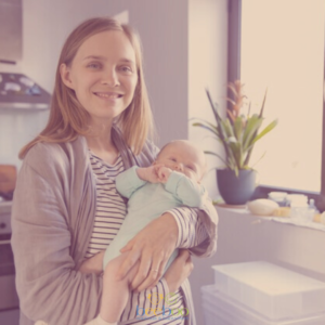 A nanny holds an infant in her arms, providing safe, attentive care, illustrating BeeBoo's home childcare services.