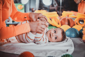 A dedicated nanny helps a little boy get dressed, illustrating the commitment and professionalism of BeeBoo's home childcare services. A moment of intimacy and well-being where each child is looked after with care and attention.